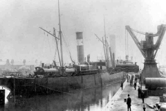 Loading locomotives aboard a Bennett Steamship Co Ltd steamer.