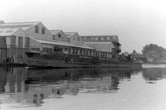 Regality moored alongside a large building.