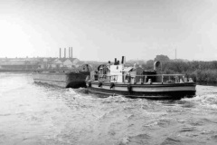 A tug pushing a coal compartment boat.