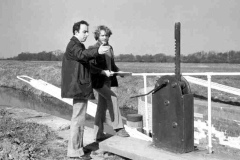 Two individuals Inspecting a recently renovated canal lock.