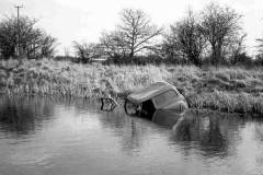 An abandoned van in a canal.