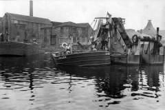 A dredger and attendant motor barge Shark at work.