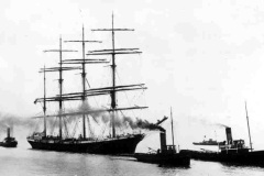 The barque Archibald Russell under tow.