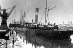 Loading locomotives aboard a steamship.