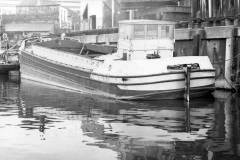 A barge berthed at a high wharf.
