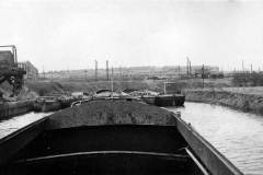 Five berthed barges in a canal basin.