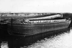 Three barges berthed on a stretch of canal.