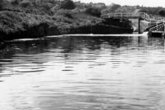 An unladen motor barge leaving a canal lock.