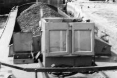 A coal laden motor barge in a lock.