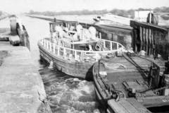 A British Waterways diesel tug leaving a lock.