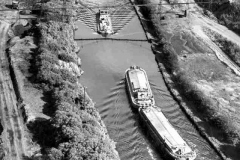 A barge approaching one towing a dumb barge.