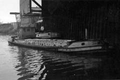 A barge berthed across the bow of another vessel.