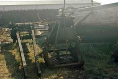 A winch and grab alongside a wooden vessel.