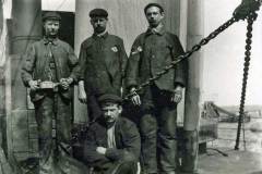 Men posing aboard a vessel.