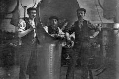 Three workers posing with a ventilation cowl.