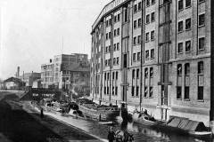 Vessels moored by a warehouse.