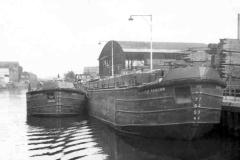 Barge Humber Renown unladen alongside a timber yard.