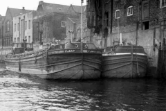 Flakit and Cuber moored alongside buildings.