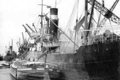 Loading a powdered cargo from a steamship into a dumb barge.