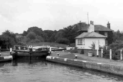 A lock, lock keeper's house, tow path and bridge.