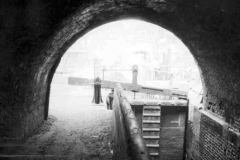 A narrow canal lock under a bridge.