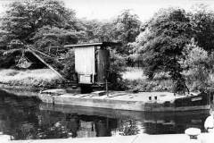 A small canal dredger moored on a canal.