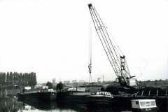 Four motor barges being loaded with timber.