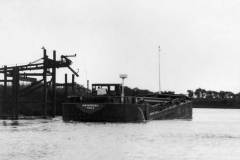 Barge Swinderby manoeuvring alongside a canal aggregate drop.