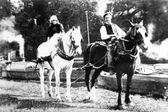 A couple astride their draft horses.