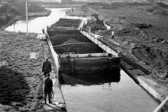 Compartment boats working through a lock.