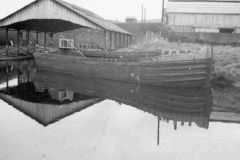 \'West Country\' size dumb barge Angela Jane in front of a covered canal basin.