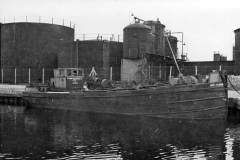Barges moored at a canalside factory.