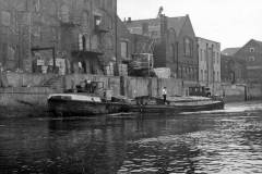Two motor barges alongside a wharf.