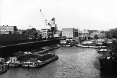 Coal-laden motor barges await unloading.