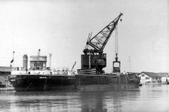 Goole\'s 50 ton crane is loading coal from a railway wagon into the collier Climping.