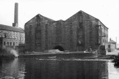 A barge moored alongside a warehouse.