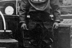 A diver posing on the side of a canal lock.