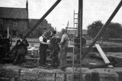 A diver being helped to get into his diving gear.