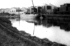 A moored barge near warehouses.