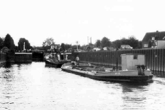 Barge under tow approaching a lock.