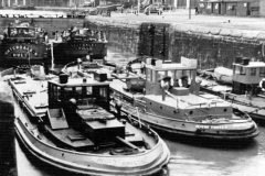 Five motor barges in a lock prior to entering port.